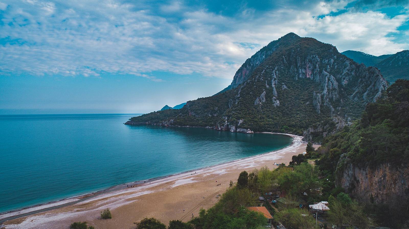 Olympos and Çıralı pebble beach Olympos beach with pebble shore, pine forest, and mountains in the background